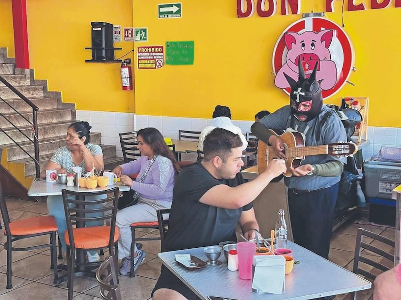 ‘El Muñeco MX’ recorre las calles del barrio para regalarle un buen rato a la gente que lo escucha cantar con su guitarra. Foto: (Sergio Trejo. El Gráfico)