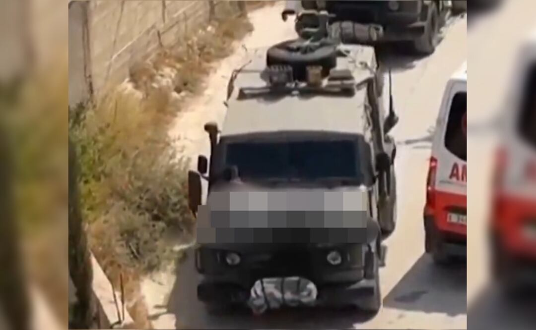 Soldados israelíes atan a un cofre de un Jeep a prisionero palestino