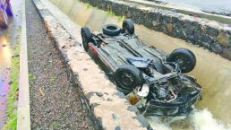 Conductor pierde control de coche en una curva y cae a dren, en Querétaro