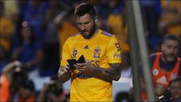Gignac con su celular durante un partido de Tigres