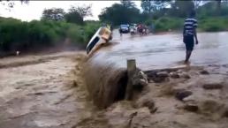 Auto es arrastrado por corriente de agua y cae en cascada| VIDEO