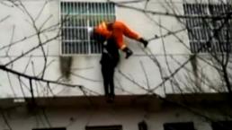 Bombero atrapa a mujer suicida en el aire | VIDEO 